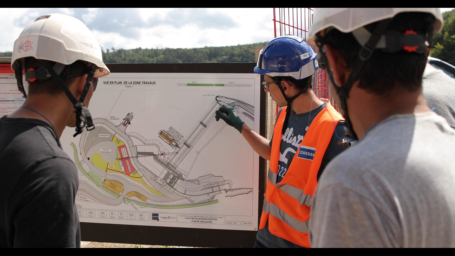 Un compagnon montre un plan sur un chantier