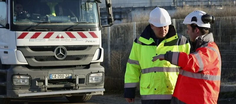 Deux salariés du BTP devant un camion sur un chantier