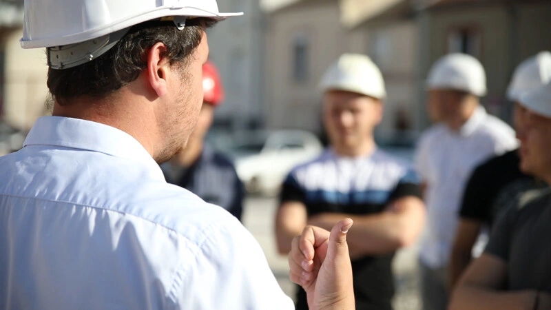 Un chef d'entreprise qui explique le chantier à ses collaborateurs